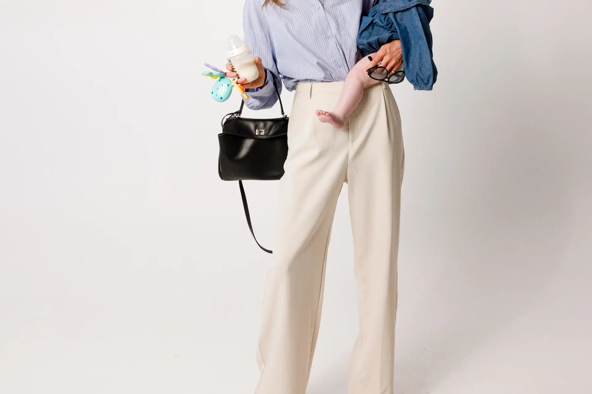 A mother carrying her baby, a bottle and her handbag